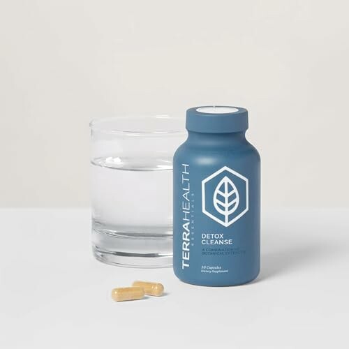 Supplement bottle labeled 'Detox Cleanse' next to a glass of water and capsules, a natural digestive reset supplement