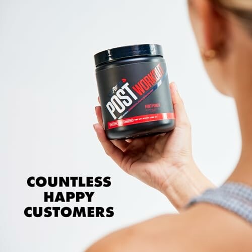 Person holding a post-workout supplement container labeled fruit punch.